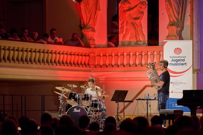 Young tuba player and drummer on one stage