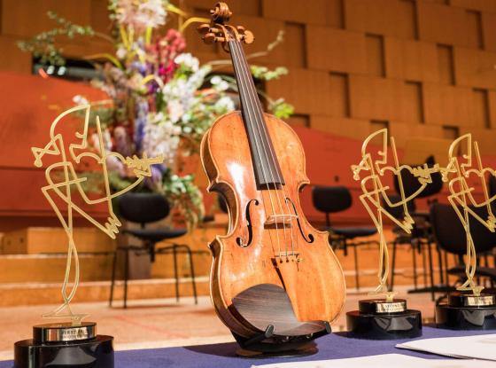 Eine Violine zwischen den Trophäen für den Joseph Joachim Violinwettbewerb 2018.